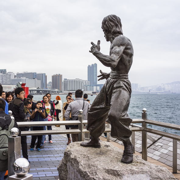 A crowd lines up to look at a statue of Bruce Lee, the founder of Jeet Kune Do.