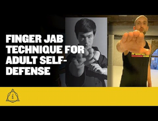 A martial artist performs a finger jab technique.