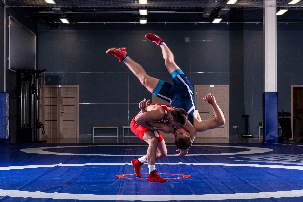 Two grappling martial arts square off with one using a takedown technique against his opponent.