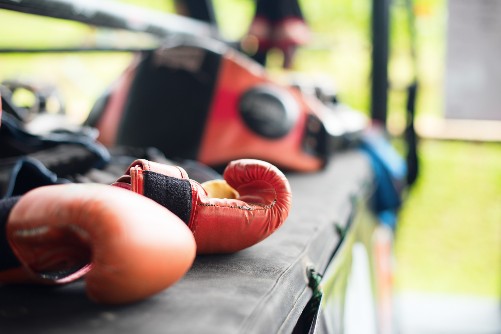 Gloves are left on a mat in the open air of a martial arts summer camp.