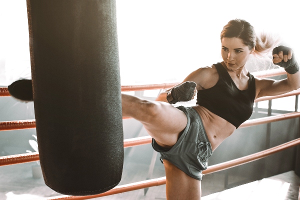 A kickboxer strikes a pad with a roundhouse kick