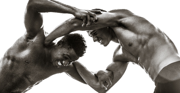 Two martial artists grapple, trying to gain an advantage over each other.