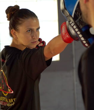 A woman in fight stance taught at NY Martial Arts Academy